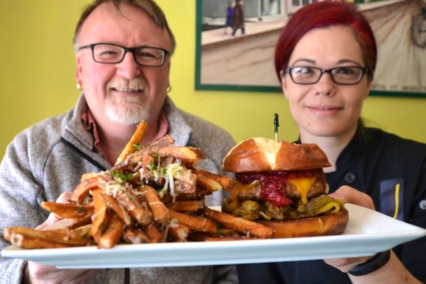 Chef John Bartlett, owner of the Capitol Pub in Middleton, and Chef Michelle Friel with the pub’s official entry in the Burger Wars that is in support of Campaign for Kids, a group helping underpriviledged children and youth in Kings County. The Capitol entry, called the Aviator, is a turkey burger with a subtle curry flavor and a cranberry sauce on a bagel bun.