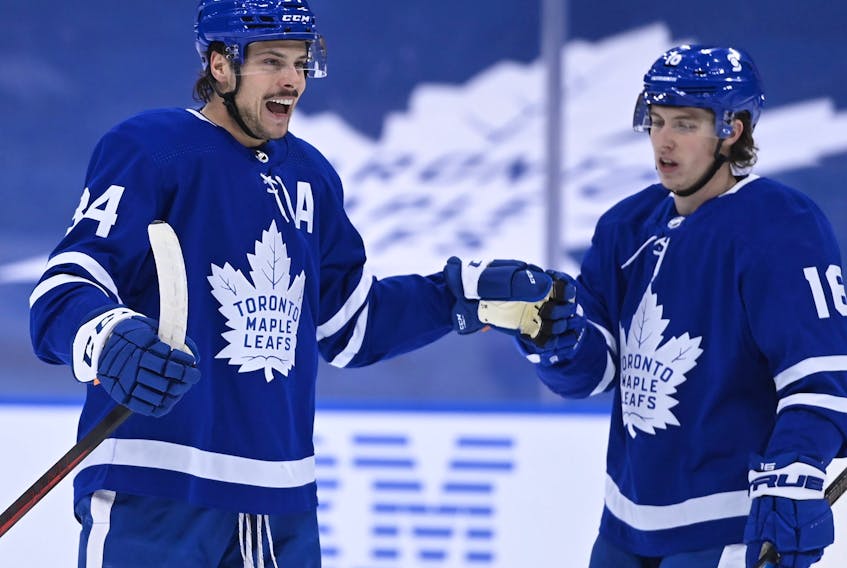 Toronto Maple Leafs centre Auston Matthews, left, celebrates his power play goal against the Ottawa Senators with teammate Leafs right wing Mitchell Marner during first period NHL hockey action in Toronto on Thursday, Feb. 18, 2021. 