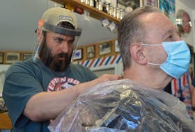 Mark MacDonald, left, of Mark’s Barbershop puts the finishing touch on a haircut for Marvin O’Neil early Friday morning. Hairstylists, barbers and many others opened their doors for the first time in weeks on Friday after some social isolation precautions were lifted. GREG MCNEIL/CAPE BRETON POST