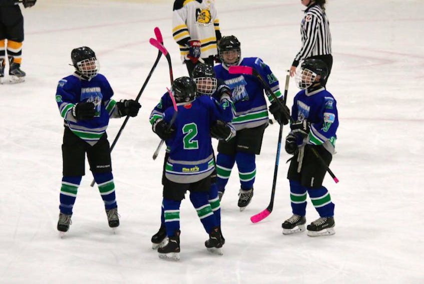 Members of the Wades Wire Traps/Five Star Roofing Bantam AA Mariners celebrate on the ice during a game against Antigonish.
