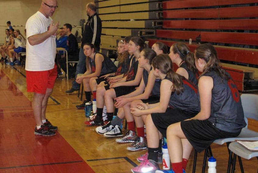 Fred Cumby speaks to players on the Bantam A Junior Axewomen basketball squad before a Jan. 25 game at Acadia University
