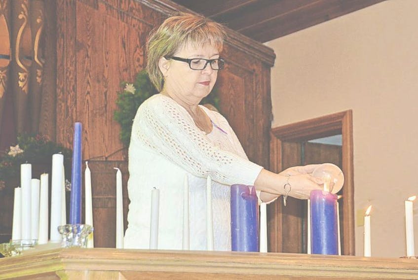 <p>Barb Broome lights a memorial candle during a ceremony Friday to mark the national day of remembrance and action on violence against women, Friday. Colin MacLean/Journal Pioneer</p>