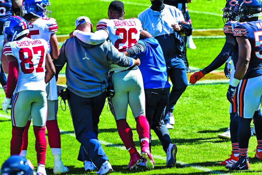 New York Giants running back Saquon Barkley is helped off the field with what appears to be aseason-ending knee injury suffered Sunday in Chicago.