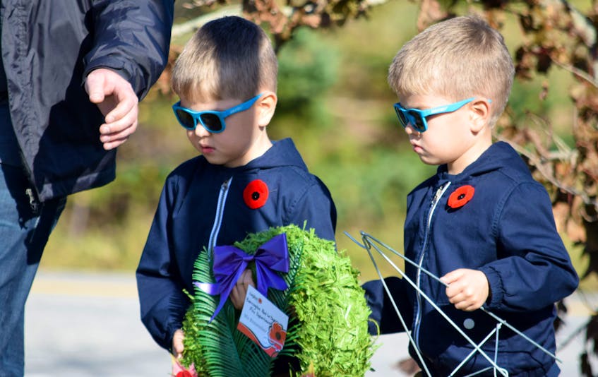 Two young boys carry a wreath to be laid at the Barrington cenotaph during the Remembrance Day community service.