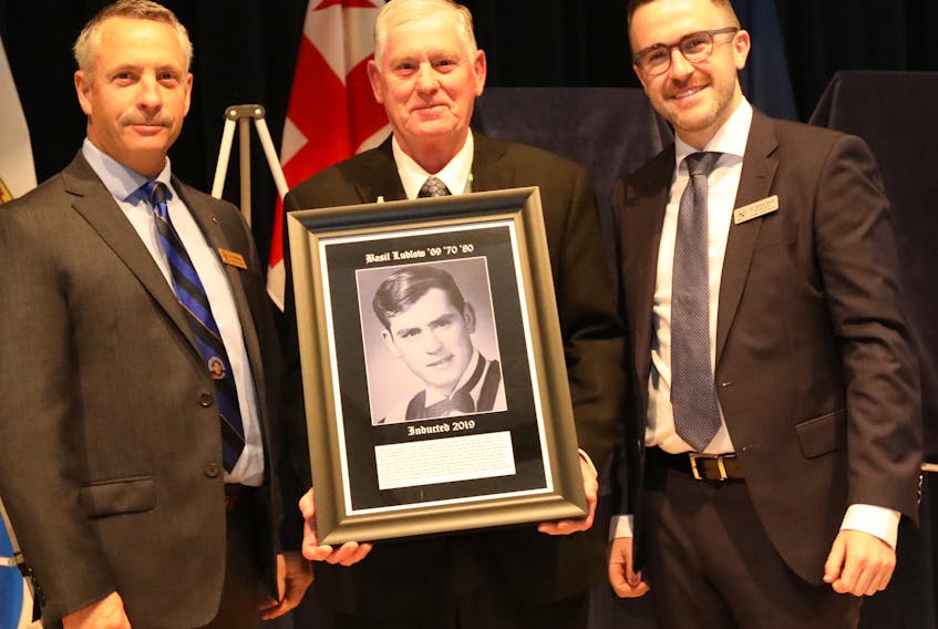 Basil Ludlow (center) of Antigonish accepted his St. F.X. Hall of Honour portrait from interim university president Kevin Wamsley (left) and St. F.X. Alumni Association president Marc Rodrigue during Homecoming 2019 festivities on campus. Contributed