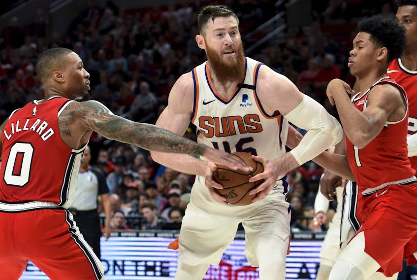 Aron Baynes (centre), drives between a pair of Portland Trail Blazers last season. Acquired by Toronto, Baynes is expected to be the Raptors' starting centre.
