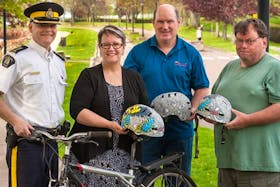 RCMP Criminal Operations Officer, Superintendent Mac Richards representing Commanding Officer, Chief Superintendent Joanne Crampton, joins Transportation, Infrastructure and Energy Minister Paula Biggar, Mike Connolly of Cycling P.E.I. and Kenneth Murnaghan of the Brain Injury Association of P.E.I. near Charlottetown's Victoria Park bike lanes. The police, government and community groups are cooperating to promote the use of bicycle helmets on Prince Edward Island.