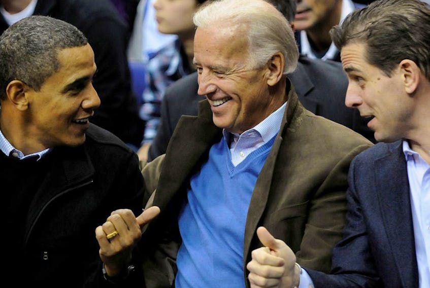 Joe Biden, centre, and his son Hunter attend an NCAA basketball game between Georgetown University and Duke University with then-president Barack Obama in Washington in a file photo from Jan. 30, 2010.
