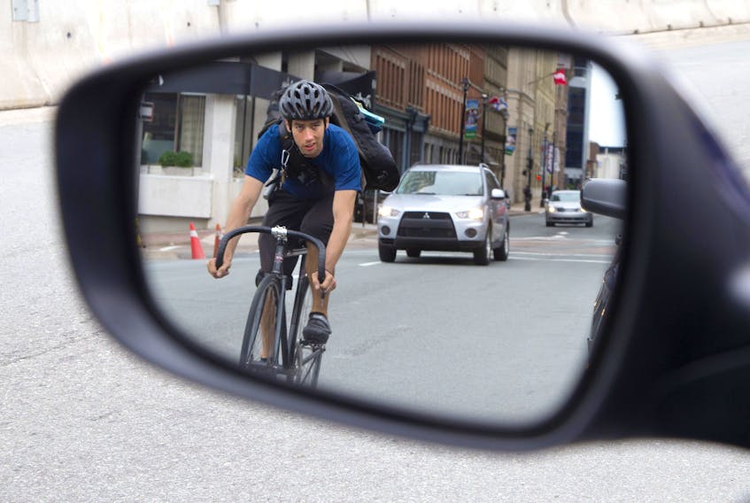 A cyclist is reflected in a side mirror pedals down Hollis St. on Wednesday, June 25, 2014. halifax council is contemplating bike lanes one certain streets in the downtown core.