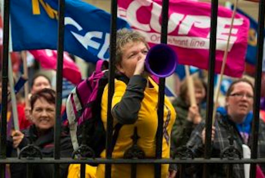 ['Protesters from public sector unions march outside the legislature in Halifax on Monday, September 29, 2014. The Nova Scotia government is introducing a bill that would merge the number of bargaining units in the health-care sector from 50 to four by April 1.']