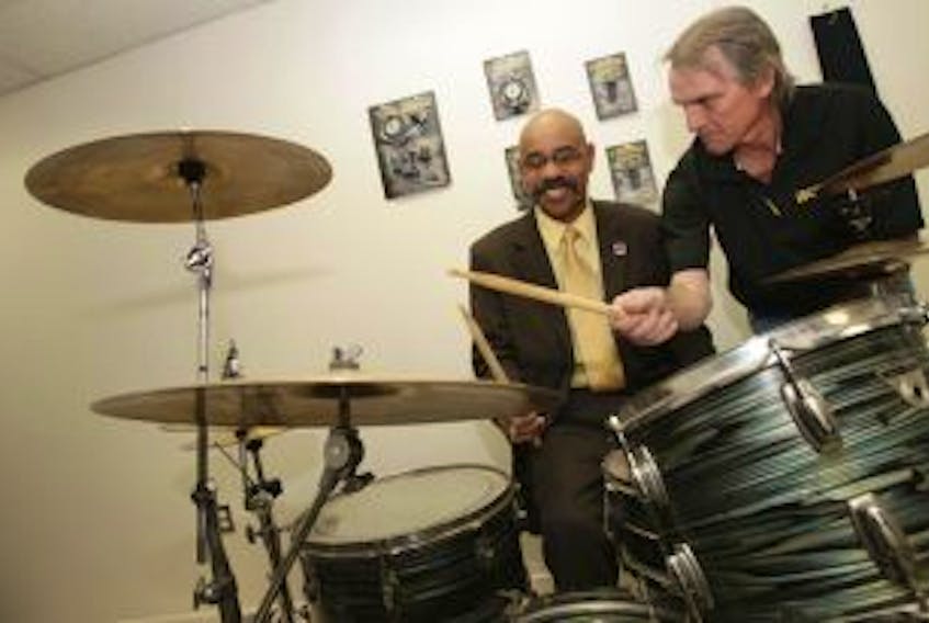 ['In this file photo from December 2011, Percy Paris, left, Nova Scotia minister of economic and rural development, gets a quick drumming lesson from Bill Coady, local inventor behind the Coady Clutch, shortly after Paris announced a provincial loan of $300,000 for Billdidit Inc. The Sydport-based drum hardware company has apparently reached the end of the line: Billdidit Inc. will sell off its assets in an online auction later this month.']
