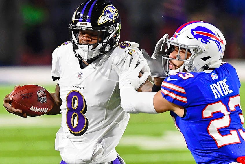 Baltimore Ravens quarterback Lamar Jackson (8) stiff arms Buffalo Bills strong safety Micah Hyde (23) during the AFC Divisional Round playoff game in Buffalo. 