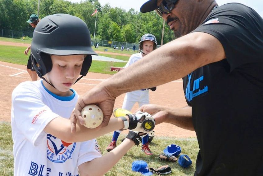 Former Toronto Blue Jay Jesse Barfield gives some batting instruction to Campbell Smith during Honda Super Camp, part of the Blue Jays Baseball Academy, Monday in Charlottetown.