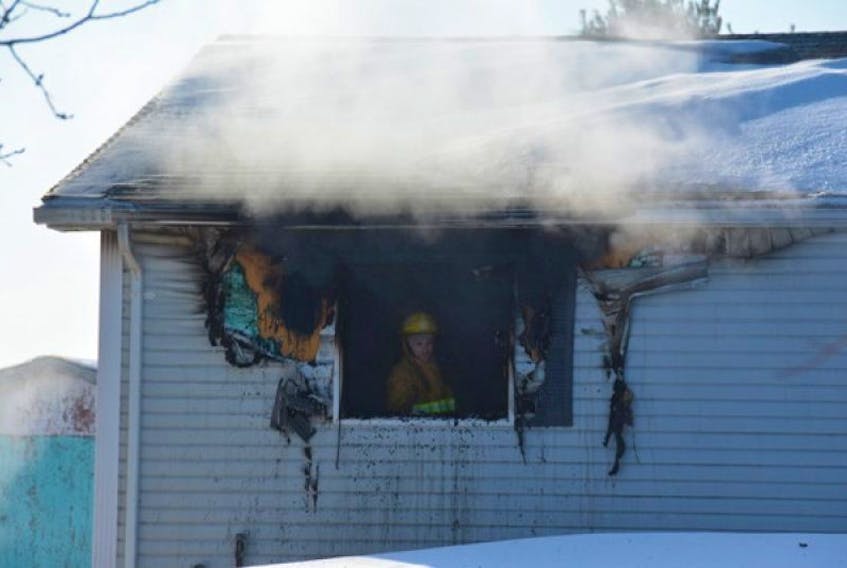 A firefighter looks out from a ruined window in a home on Blue Shank Road, Tuesday morning. The home sustained significant damage in a blaze that is believed to have started in a bedroom. Colin MacLean/Journal Pioneer