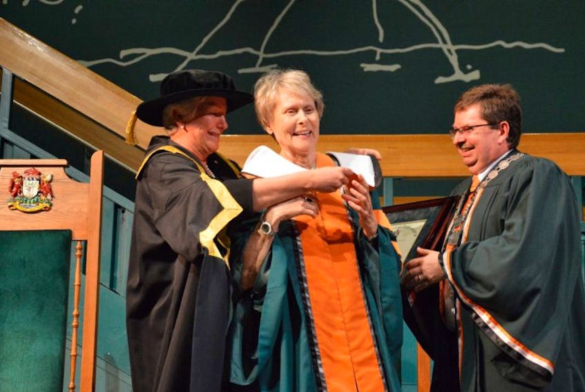 Cape Breton University chancellor Annette Verschuren, left, fixes Dr. Roberta Bondar’s robes as she receives an Honourary Doctorate of Letters from the university on Saturday at a special convocation held at Baddeck’s Alexander Graham Bell Museum while Dr. Dale Keefe, CBU’s president and vice-chancellor, right, gets ready to shake Bondar’s hand.