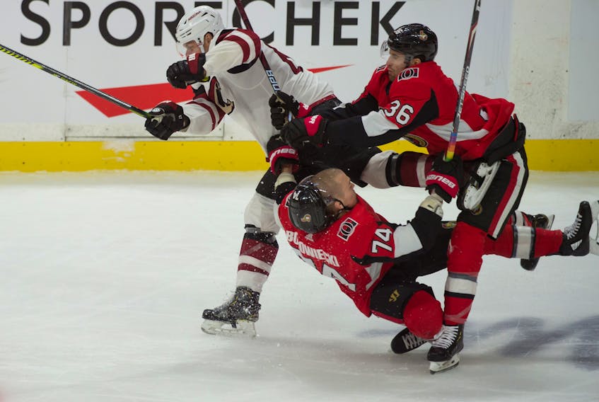 Senators’ Mark Borowiecki takes a hit from Arizona Coyotes’ Lawson Crouse during the third period of Thursday night’s game 
at the Canadian Tire Centre. Borowiecki sustained an ankle injury and will be out indefinitely. (USA TODAY SPORTS)