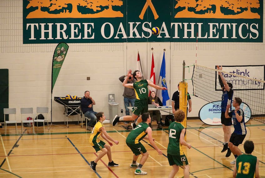 Ben MacDougall (10), centre, spikes the ball for the winning point against the Bluefield Bobcats in the championship of the PEISAA Senior AAA Boys Volleyball league.