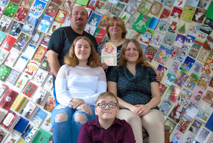 Everett Crewe and his family in front of his many prized Christmas cards. In back is Everett and Pauline; centre, from left, Michelle and Britney; and forefront is Todd. CONTRIBUTED