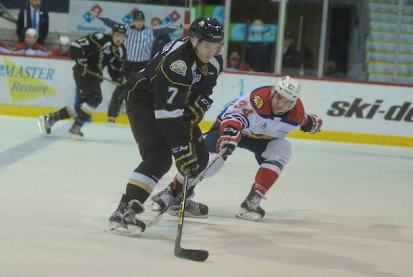 Charlottetown Islanders right-winger Bradley Kennedy, left, protects the puck from Moncton Wildcats centre Kevin Klima.