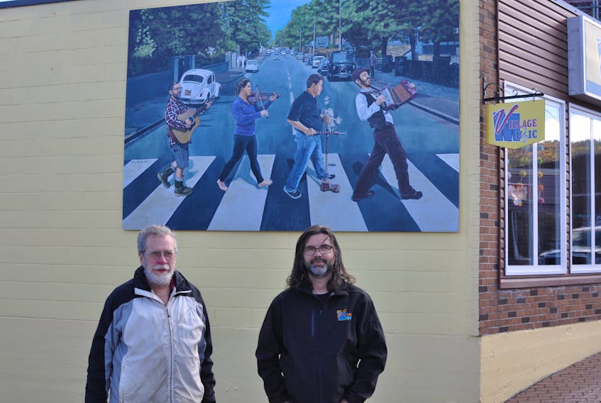Lorne Bishop (left) took Sheldon Power’s vision and turned the image from the Beatles’ “Abbey Road” album cover into one featuring local musicians. The mural is a focal point on Power’s Village Music shop on Broadway in Corner Brook. 
