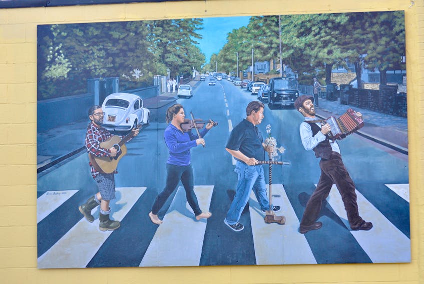 (From left) Village Music owner Sheldon Power playing guitar, Leah Vokey Sing playing fiddle, Wade Jones with an ugly stick and Keelan Purchase playing an accordion are featured in an “Abbey Road”-styled mural painted by Lorne Bishop that now adorns the side of Village Music on Broadway in Corner Brook. 