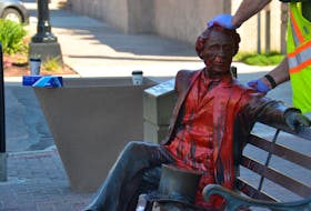 City workers clean off red paint dumped on the John A. Macdonald statue on June 19. 