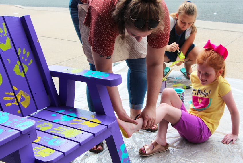 Stella Merry decided a hand-print is nice but a foot-print is even better, when contributing to the ‘buddy bench’ Aug. 16, a collaboration between the R.K. MacDonald Nursing Home and Antigonish: Art after Dark Festival which will sit outside the People’s Place Library.