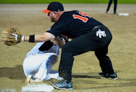 Kelly’s Pub Bulldogs player Blair Ezekiel slides safely into thrid base as NTV Hitmen thrid baseman Chris Murphy waits for the throw from the outfield during softball action at Lions Park Tuesday night.

Keith Gosse/The Telegram