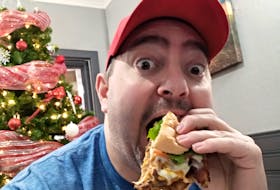 Corner Brook Best in the West Burger Competition social media influencer Cory Sheppard opens wide as he devours a burger. CONTRIBUTED