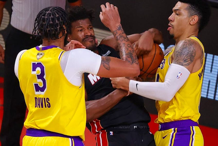 Anthony Davis (left) and Danny Green of the Los Angeles Lakers defend Jimmy Butler of the Miami Heat during the fourth quarter in Game 4 of the 2020 NBA Finals on Oct. 6, 2020, in Lake Buena Vista, Fla. 
