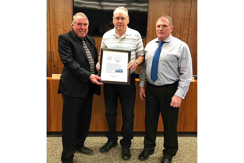 Municipality of Pictou County Warden Robert Parker, left, and District 10 Coun. Randy Thompson present Wayne Buttle with a plaque of recognition for his commitment and work with District 13 Recreation and Planning Commission as well as the Ivor MacDonald Memorial Arena. Buttle has been arena manager for 41 years.