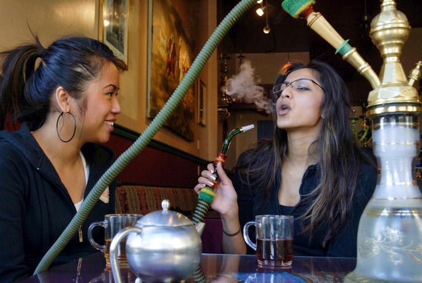 Two women enjoy shisha at Cafe Mediterranean, a hookah lounge in downtown Calgary. 