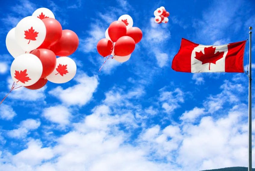 Canadian maple leaf flag and balloons in the sky for Canada day.