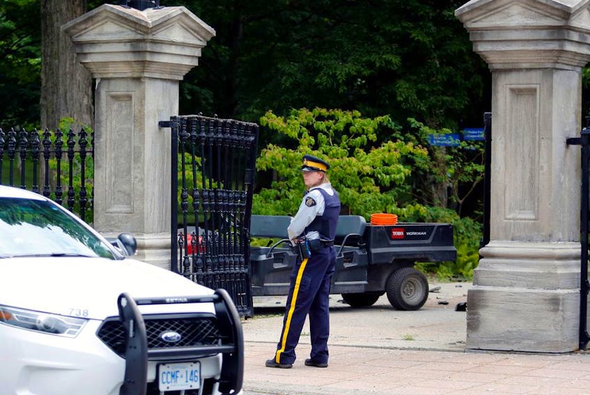 A police officer stands near a damaged gate at Rideau Hall, the property where Canadian Prime Minister Justin Trudeau lives, after an armed man rammed the gate with a pickup truck to gain access to the grounds.