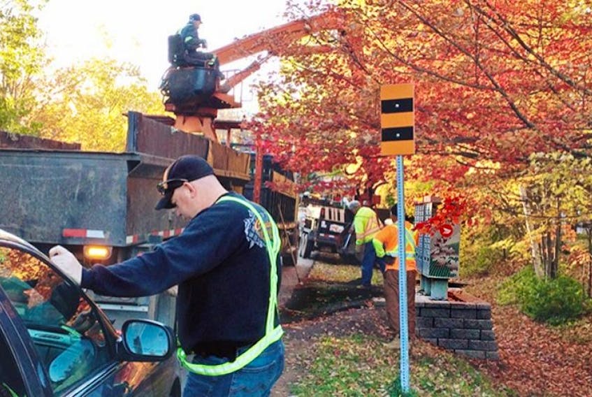 A crew works on one of the recently installed community mailboxes on MacMillan Crescent in Charlottetown. Patio stones that had been part of the base are being removed from over 70 such mailbox installations on P.E.I., being replaced with asphalt.