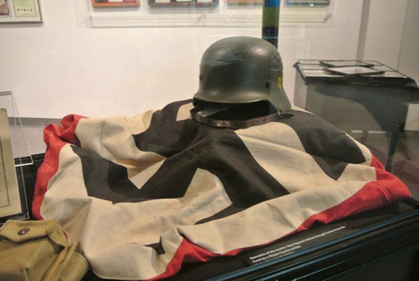 The spoils of war: a German helmet and Nazi swastika flag captured during WW2