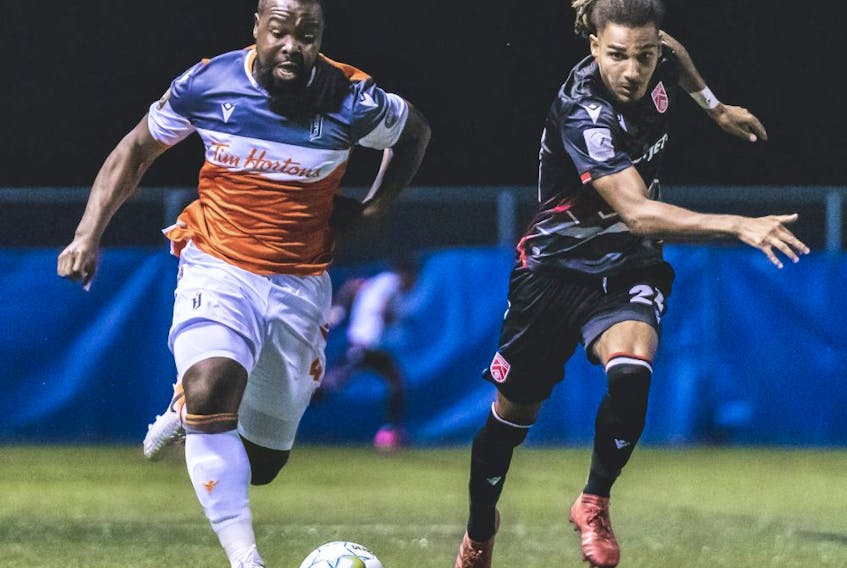 Cavalry FC fullback Mohamed Farsi (R) competes for a ball against  Forge FC defender Dominic Samuel (L) on Thursday, August 13, 2020 during the opening game of the Canadian Premier League Island Games soccer action in Charlottetown, Prince Edward Island. 
