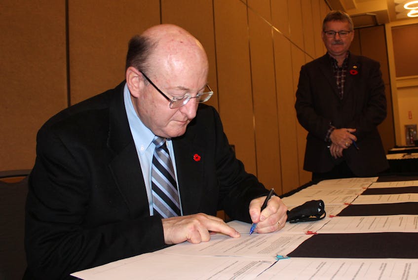 Robert Shepherd, president of the Nova Scotia Construction Labour Relations Association, signed a new five-year contract with Cape Breton Building and Construction Trades Council on Tuesday at the Membertou Trade and Convention Centre. Looking on is Jack Wall, president of the trades council, who also signed the contract on Tuesday along with members of various trades across the island. GREG MCNEIL • CAPE BRETON POST