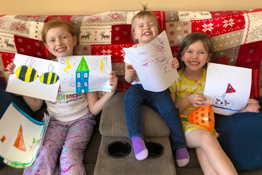 Neelie Bennett, 7, left, and sisters Fable Mae, 2, and Larken, 4, of Big Pond, with some of the pictures they drew and sold on Facebook for $2 each, raising $500 for the Cape Breton Regional Hospital Foundation in one day. CONTRIBUTED