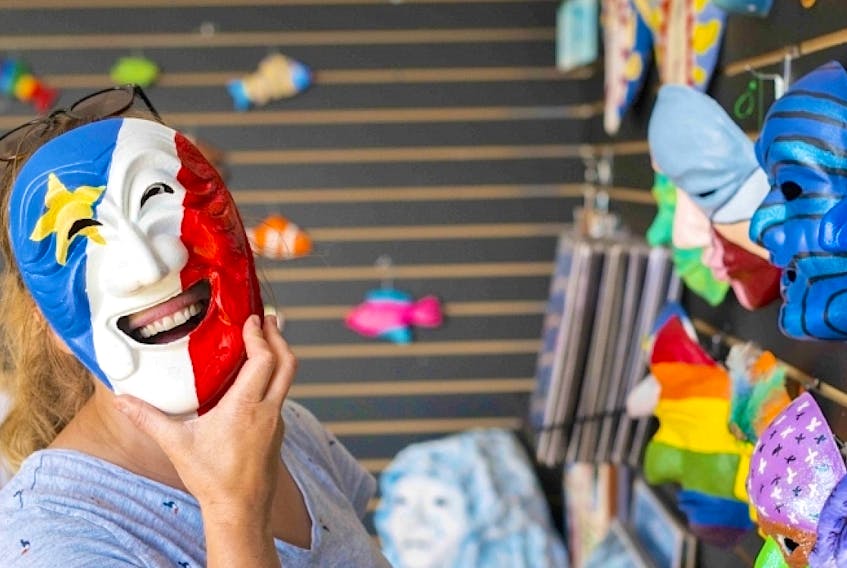 A person holds a papier-mâché mask painted like the Acadian flag at the Mi-Carême Interpretive Centre in Grand Étang. The masks are worn by costumed revellers who roam from house to house in Chéticamp, Saint-Joseph-du-Moine and Grand Étang during Mi-Carêm, a weeklong celebration that is a combination of Halloween, Mardi Gras and an old-fashioned Acadian kitchen party. Contributed/Mi-Carême Interpretive Centre





