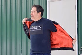 Origin Coast founder and chief executive officer Michael Fong braves Wednesday's sub-zero temperature to show off the shirted logo of his new company Origin Coast. The Sydport-based operation has been granted Health Canada licenses to cultivate cannabis for the recreational and medical markets. DAVID JALA/CAPE BRETON POST