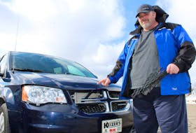 Holding a piece of the grill from his Dodge Caravan, George MacLeod points to some of the damage caused after a large chunk of ice flew off a school bus roof and slammed into his vehicle while he was driving on Highway 125 near the Cape Breton Regional Hospital. Chris Connors/Cape Breton Post




