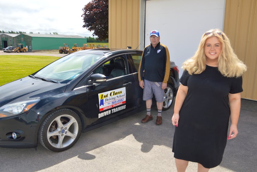 New Driver Megan Robertson, right, poses for a picture as Eric MacRae, owner of 1st Class Driving School, stands near the vehicle on Wednesday. Robertson recently took her road test and passed, months after COVID-19 forced the cancellation of her original road test on March 13. JEREMY FRASER/CAPE BRETON POST