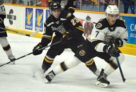 Logan Camp of the Cape Breton Eagles, left, pressures Charlottetown Islanders defenceman Oscar Plandowski for the puck during Quebec Major Junior Hockey League action at Centre 200 in Sydney last month. Camp has appeared in all 10 games for the Eagles this season. JEREMY FRASER • CAPE BRETON POST