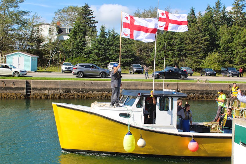 One of the moderate livelihood fishing boats heading out into the St. Peter's canal. The boat is flying Mi'kmaq grand council flags as the driver of the boat holds up the tags issued by Potlotek First Nation. CAPE BRETON POST FILE