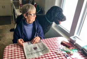 Helen MacLeod and her dog Bailey enjoy the view outside her kitchen window, like they usually do every morning, with him perched behind her on the seat while MacLeod reads the paper. Thanks to ElderDog CBRM, MacLeod, 75, is able to get help walk Bailey and she is grateful for the free services. NICOLE SULLIVAN/CAPE BRETON POST 