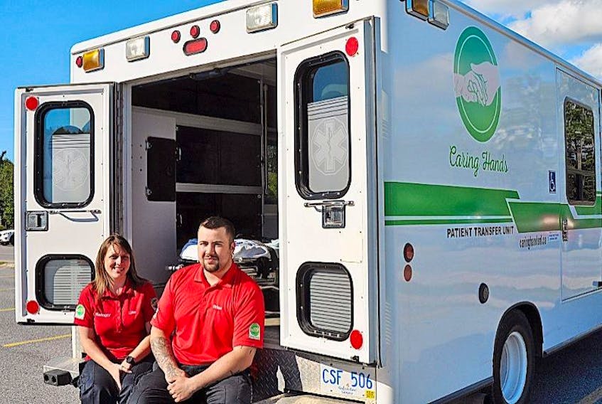 <p>Caring Hands manager Lisa Blanchard and Brian Hughes are seen outside one of the two patient transfer vehicles operating in Corner Brook.</p>
