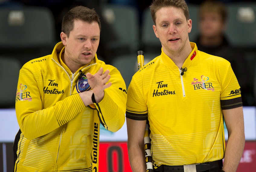 Manitoba skip Jason Gunnlaugson, left, and third Adam Casey discuss strategy during the 2021 Tim Hortons Brier Canadian men’s curling championship in Calgary this week.