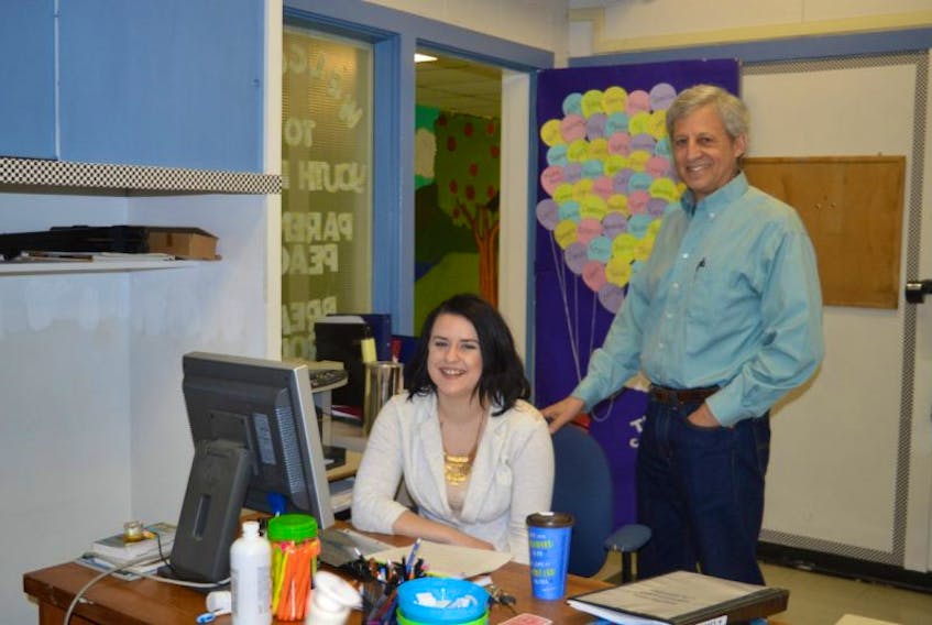 Kelsey MacNeil, a program assistant at the Educational Program Innovations Charity, works at her Sydney office desk while founder and supervisor Barry Waldman looks on.