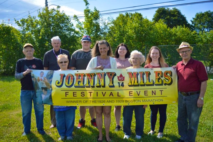 Organizers of the annual Johnny Miles Festival hold the festival banner while making final preparations on Tuesday. The festival, in memory of hometown hero Johnny Miles, will begin on Thursday. From left, front, Melvin Bond, Merdina Bond, Kim Rideout, Jean Ramsey, Kiersten Penny and Eugene Ramsey; back, Martin Pickup, Shawn Magnan and Caiden MacKinnon.
